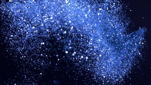Super slow motion of glittering blue particles on black background. Shallow depth of focus. Filmed on high speed cinema camera, 1000 fps.
