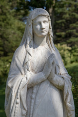 Fototapeta premium Closeup bust of woman praying statue in garden.