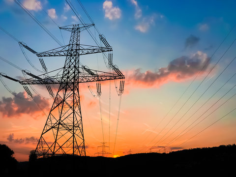 Electricity tower during red sunset with cloudy blue sky