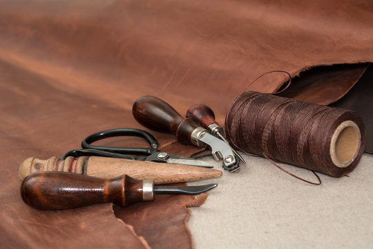 Tools and pieces of brown leather. Manufacture of goods
