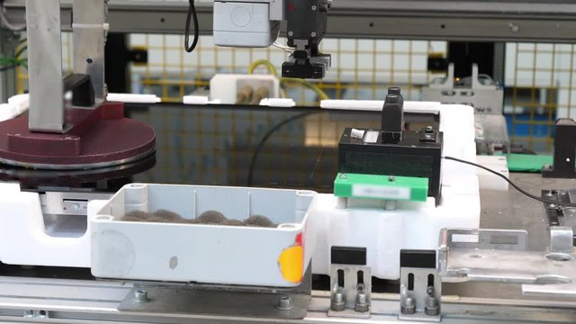 Production of induction hobs, robot tests the product, close up. Filmed in 4K