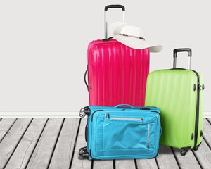 Colorful suitcases stack on wooden background