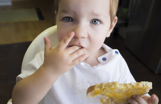 Little Baby Boy Eating Peach Jam Toast. Closeup