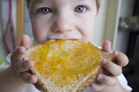 Little Baby Boy Eating Peach Jam Toast. Closeup