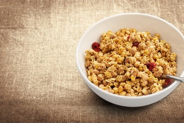 Bowl of  tasty corn flakes  on background