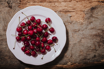 Red and juicy cherries. On a white plate