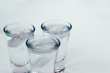 Vodka shots with ice on a white background