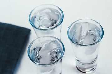 Vodka shots with ice on a white background