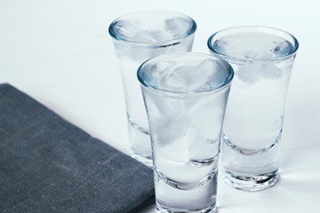 Vodka shots with ice on a white background