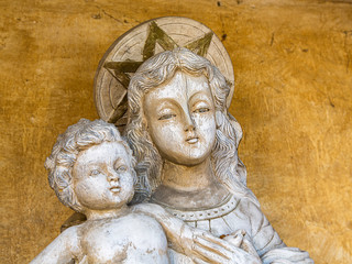 Madonna and Child Statue Against a Yellow Plaster Wall