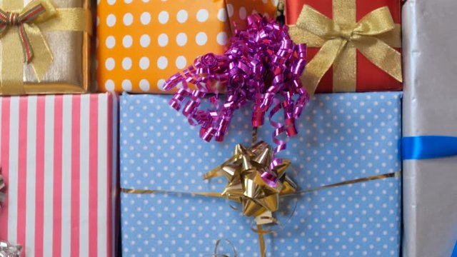 Closeup 4k video of high stack of birthday gifts in colorful boxes