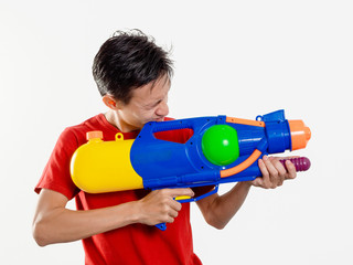 Young man with water gun toy Thailand Songkran Festival. Asian one person wear red short sleeves. isolated.