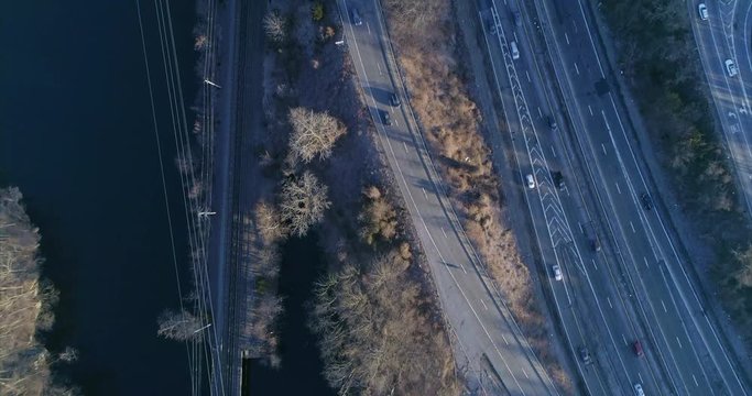 Top Down View of Cars Driving on a Highway and Train Tracks Over River