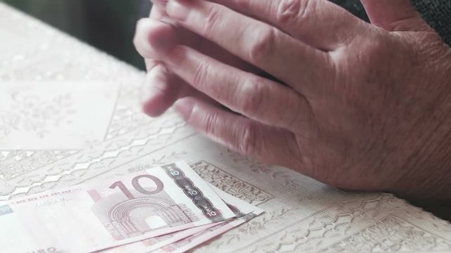 Senior lady with ten euro on table, vintage color