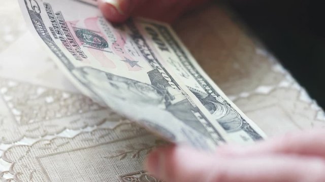 Closeup of senior lady hands with dollar bills, toned color, selective focus, very shallow DOF