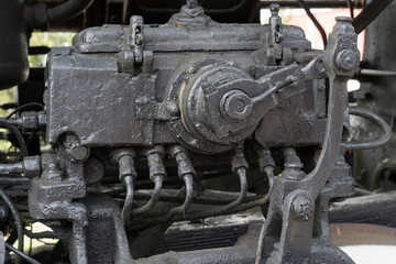 Fototapeta na wymiar Bigger details on the old steam locomotive. Heavy iron parts. Locomotive in parts. Close-up