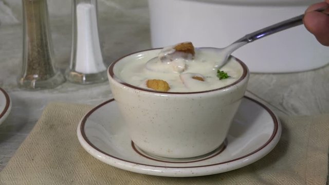Taking a spoonful of clam chowder slow motion