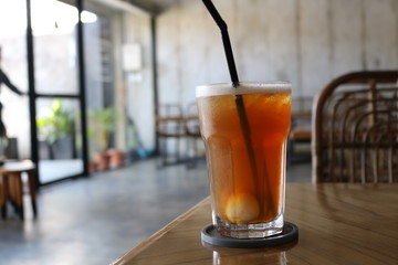 Sweet cold tea drinks are served on a wooden table inside the cafe