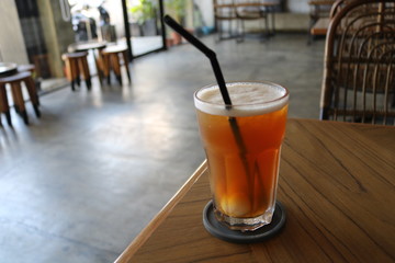 Sweet cold tea drinks are served on a wooden table inside the cafe
