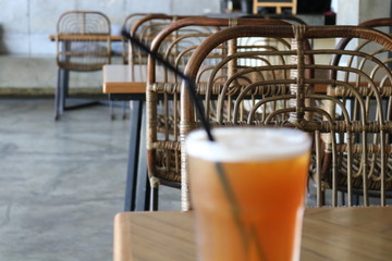 Sweet cold tea drinks are served on a wooden table inside the cafe