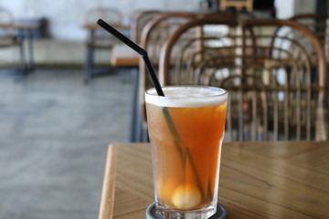 Sweet cold tea drinks are served on a wooden table inside the cafe