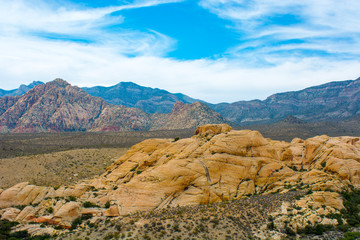 Limetsone mountains rise above sandstone rocks in the Mojave Desert