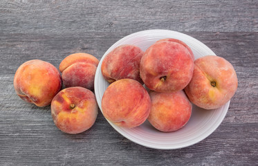 Fototapeta na wymiar Fresh, organic peaches in white bowl, on wooden background