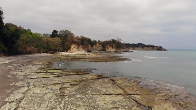Aerial shot of an undeveloped tropical beach "Playa Escondida" in Esmeraldas province, Ecuador, with exposed mudstone pavement and cliffs of the Miocene Esmeraldas Geological Formation