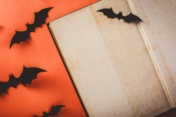 old book decorate with black bats on orange background, top view