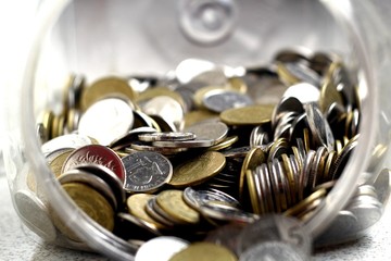 Coins spilling out of a coin bank or container
