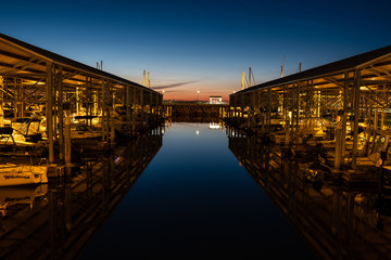 Fototapeta na wymiar A quiet night at the marina with sailboats and reflections