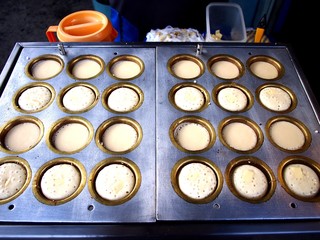 Mini pancakes being cooked on a food cart