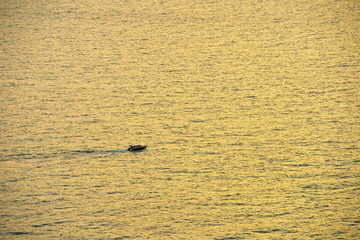 Speed Boat in the Calm Sea at Golden Sky Sunset Moment.