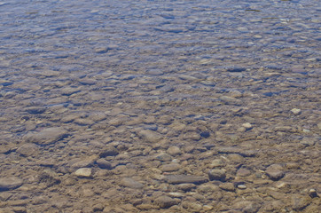The small pebbles under the clear green river. 