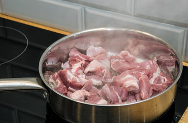 Fry pieces of meat in a frying pan.