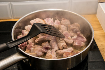 Fry pieces of meat in a frying pan.