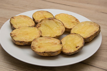 Halves of baked potatoes on a white plate.