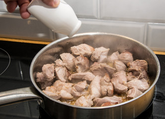 Fry pieces of meat in a frying pan.