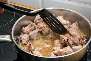 Fry pieces of meat in a frying pan.