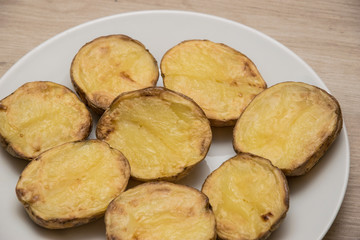 Halves of baked potatoes on a white plate.