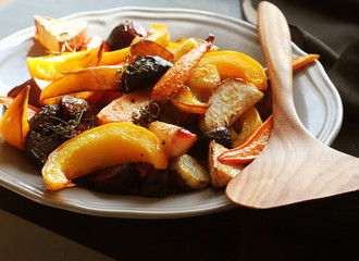 Grilled fall seasonal vegetables on plate over a dark background