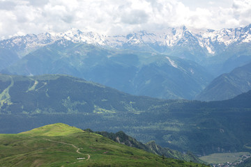 panorama of gorge with green grass and big mountain with snow