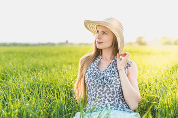 Beautiful smiling woman on a green grass outdoor