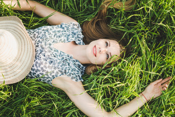 Beautiful smiling woman on a green grass outdoor