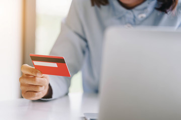 Woman hands holding credit card and using  laptop computer.Pays for purchase.Online shopping concept.