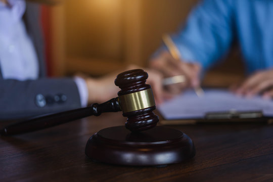 Judge gavel on wooden teable background with  Lawyer and attorney having a meeting at a law firm.