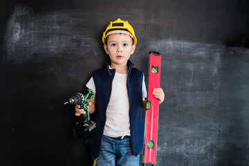 Young boy's standing with screwdriver near blackboard. Young builder. Creative design concept for 2019 calendar.