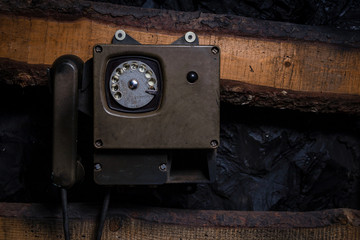 Old vintage sity telephone on an old wooden wall for use in a mine