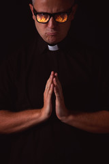 priest with a reflection of fire in glasses