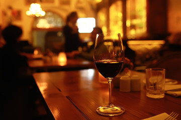 red wine glass serving / romantic dinner in the interior of the restaurant, a table served with a glass of grapes wine